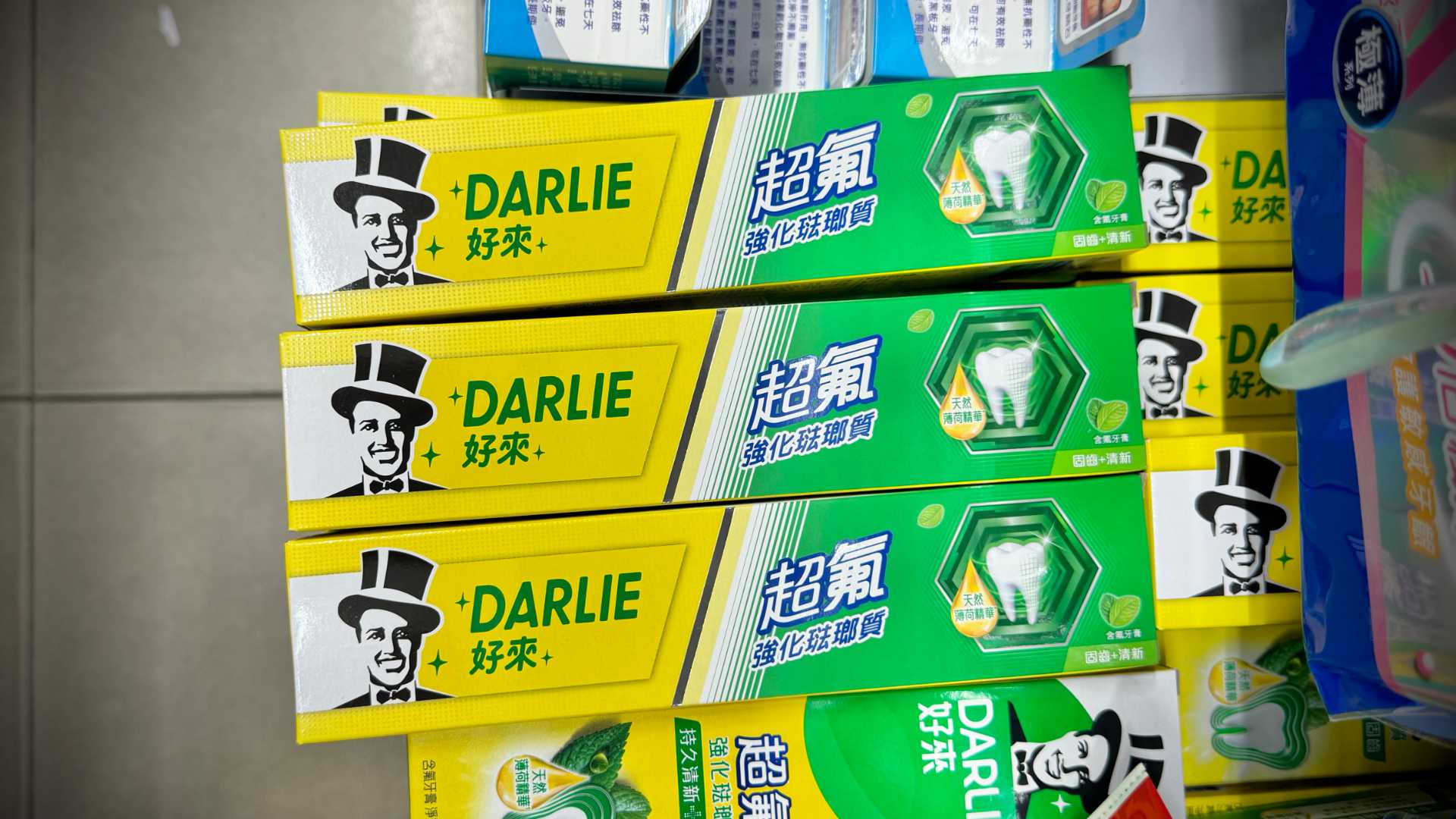 Boxes of Darlie toothpaste on a supermarket shelf.