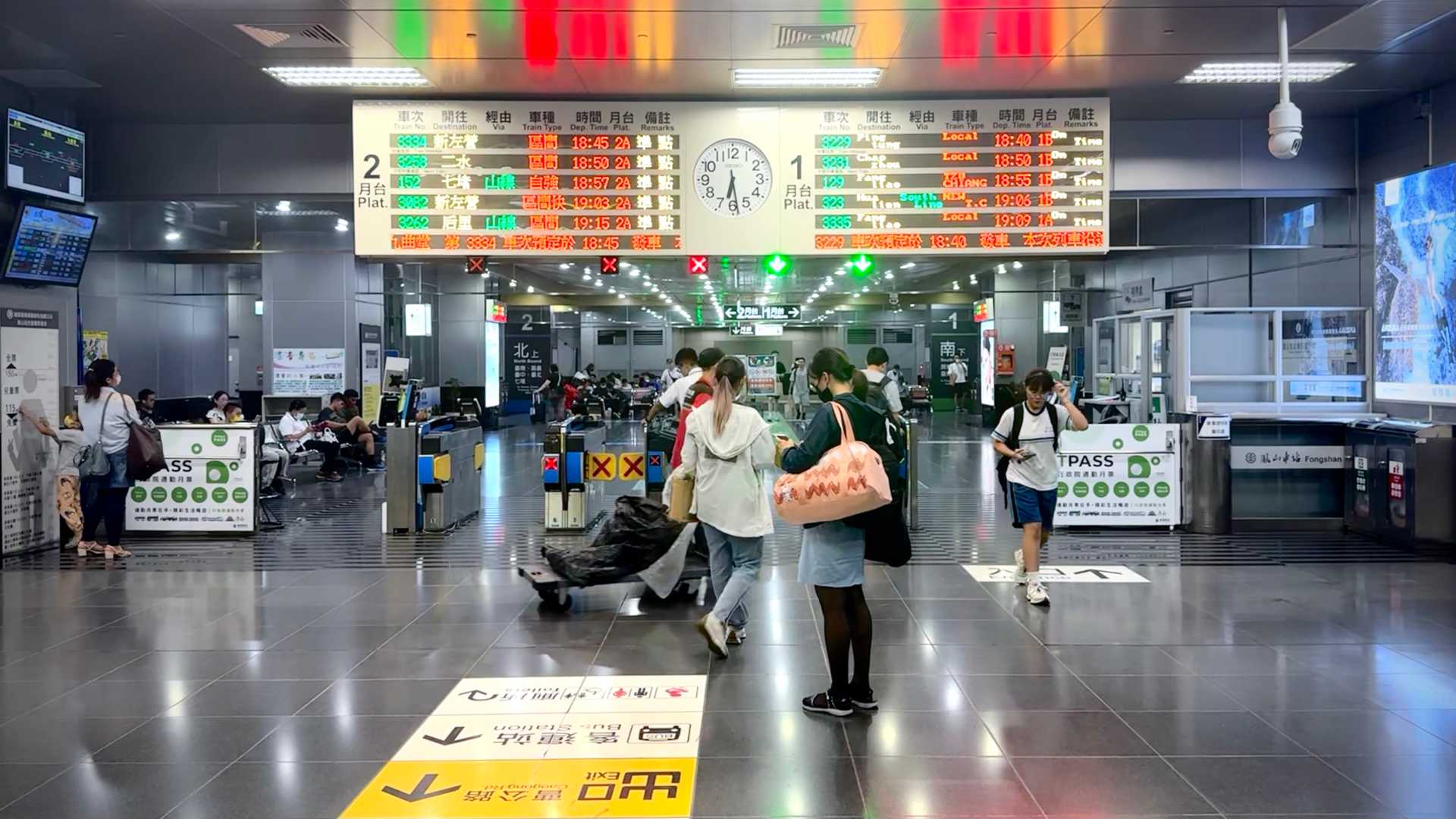 Busy interior of Fongshan Station, including a departure board. The current time is 6:28pm.