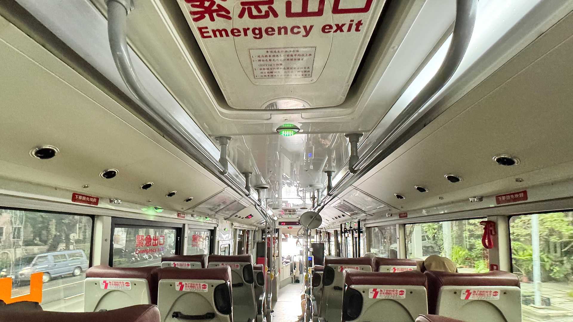 Interior of a bus in Kaohsiung, Taiwan. There are three passengers visible.