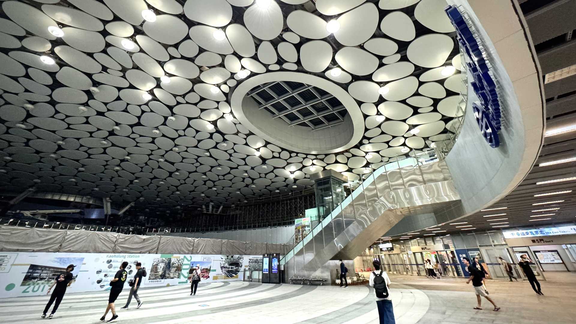 Interior of Kaohsiung Main Station. A vast high ceiling is covered in pebble-shaped ceiling tiles.