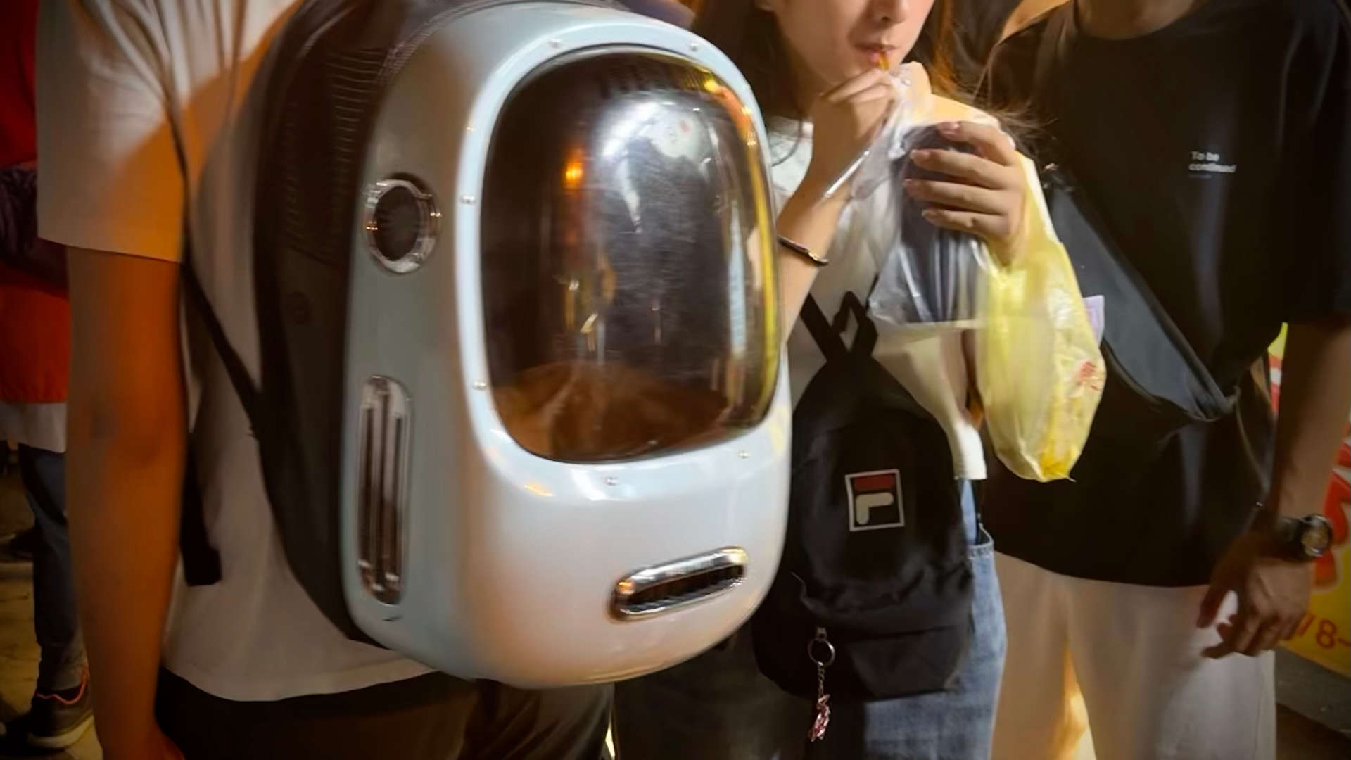 A sleeping cat inside a partially-transparent backpack. The backpack has air gaps on all sides.