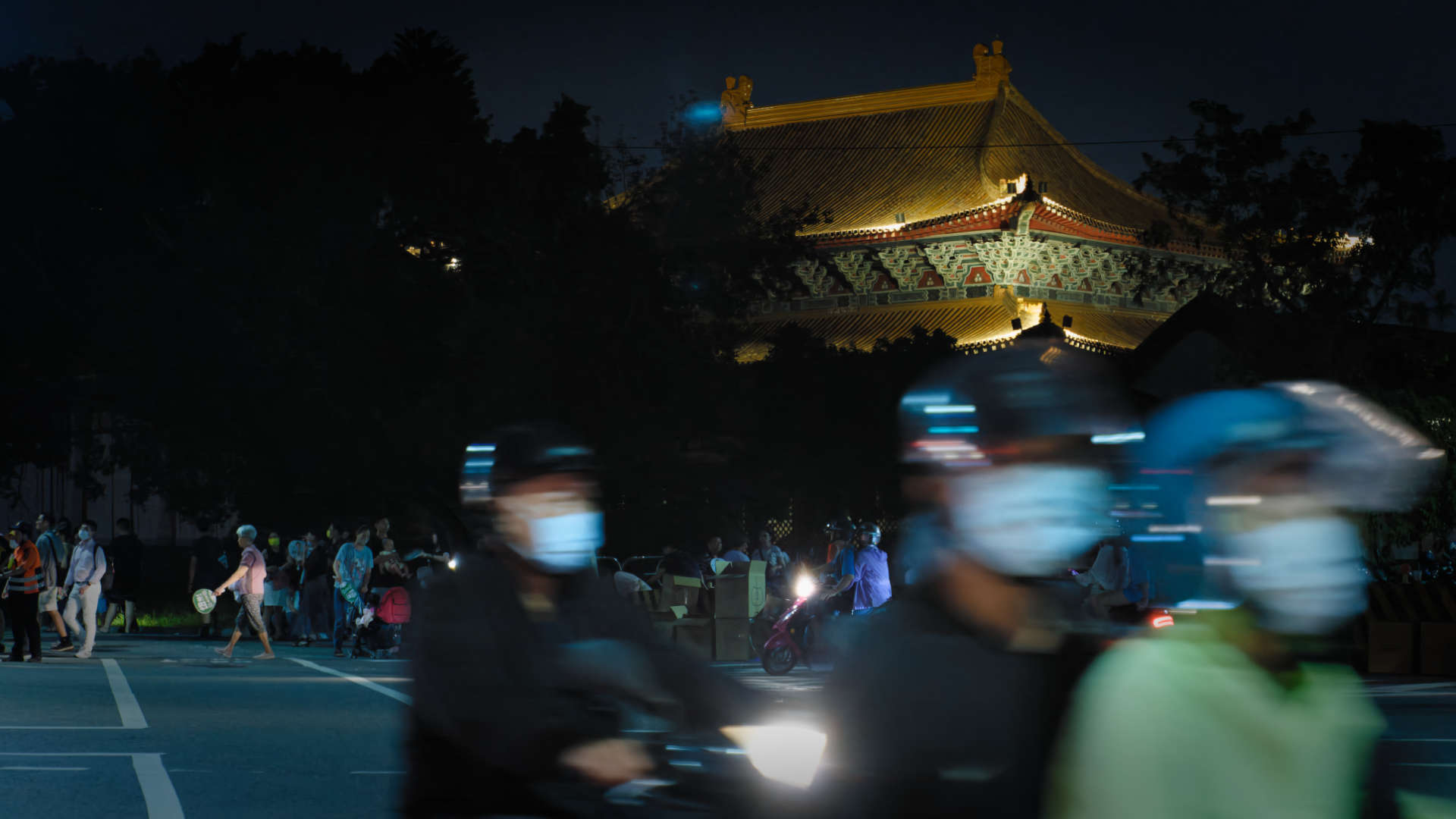 Long exposure of people driving scooters past Kaohsiung City Temple of Confucius in Zuoying District.