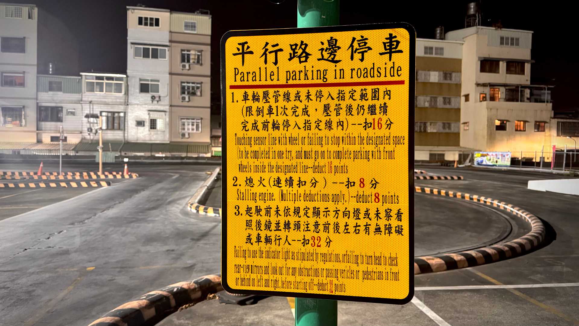 A bilingual sign next to a driving school test track in Kaohsiung, Taiwan. The Chinese characters are in a normal type, but the English characters are compressed horizontally to a ridiculous extent, making them almost unreadable.