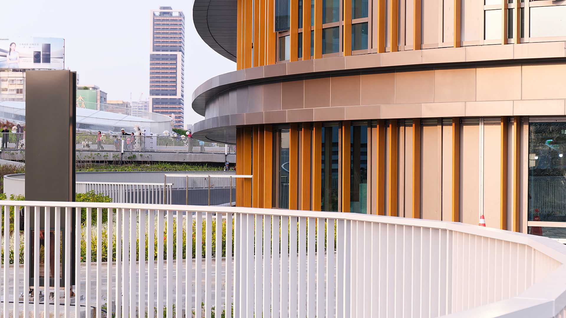 Close-up of white balustrades and the wood-clad hotel building at Kaohsiung Station.