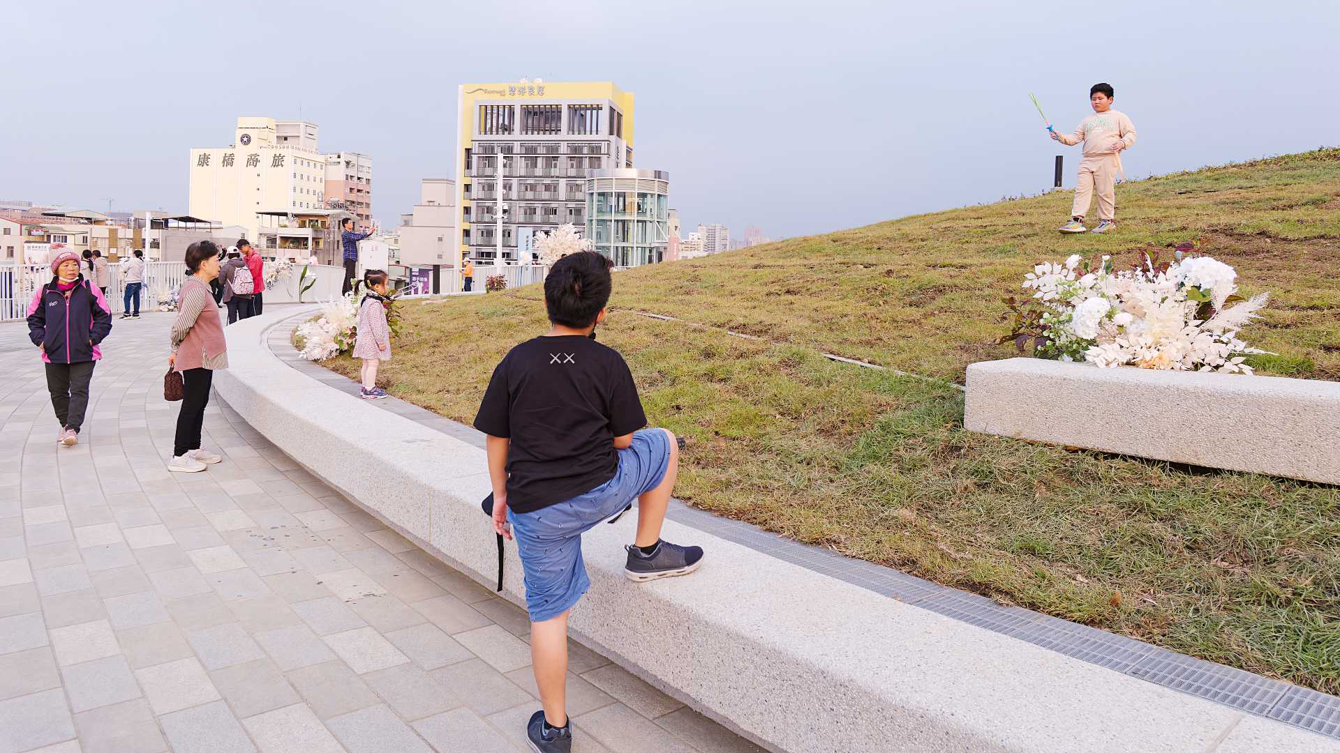 Kids playing on the grassy rooftop of Kaohsiung Station.