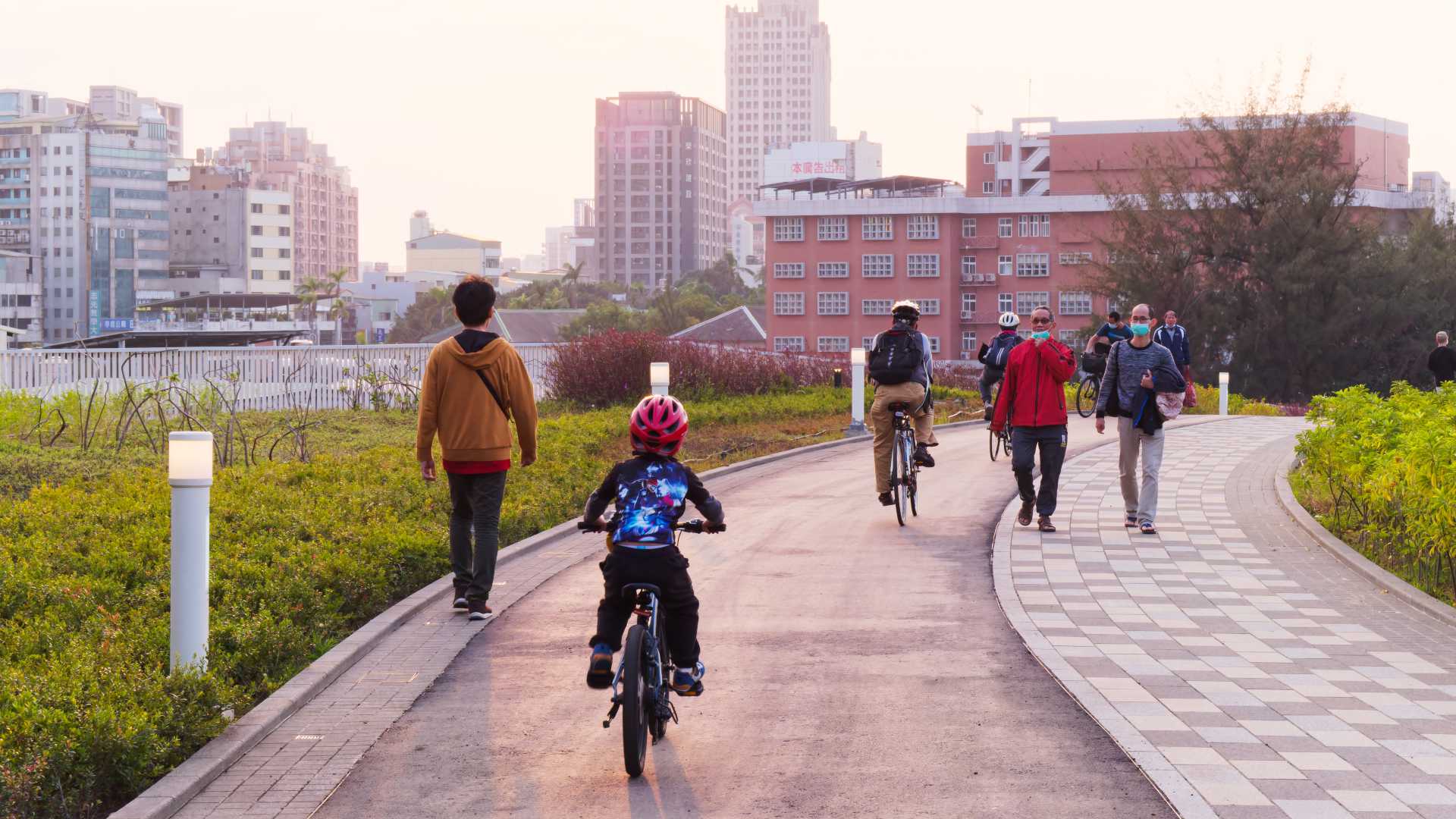 A kid rides a bike on the cycle path across Kaohsiung Station.