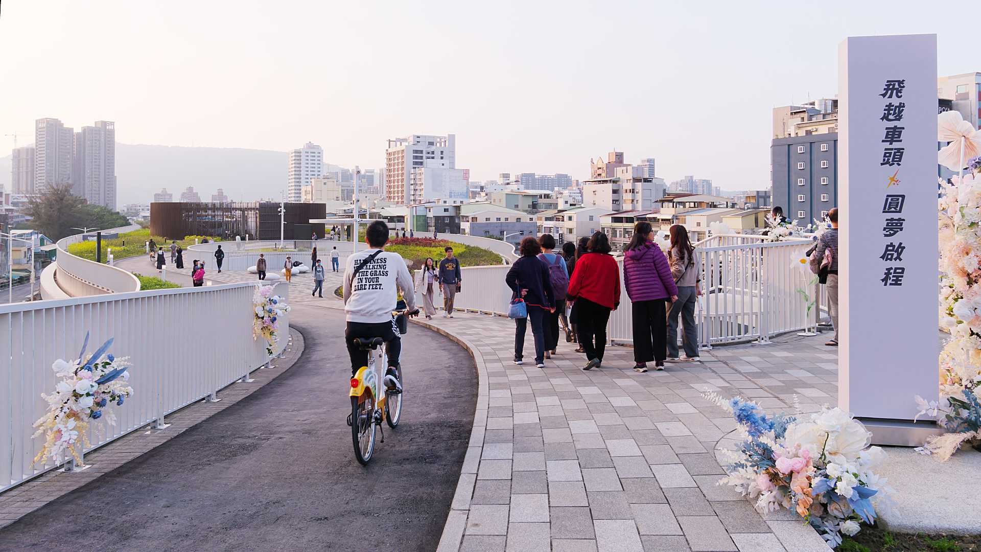 A cyclist rides a YouBike along the cyclepath across the roof of Kaohsiung Station.