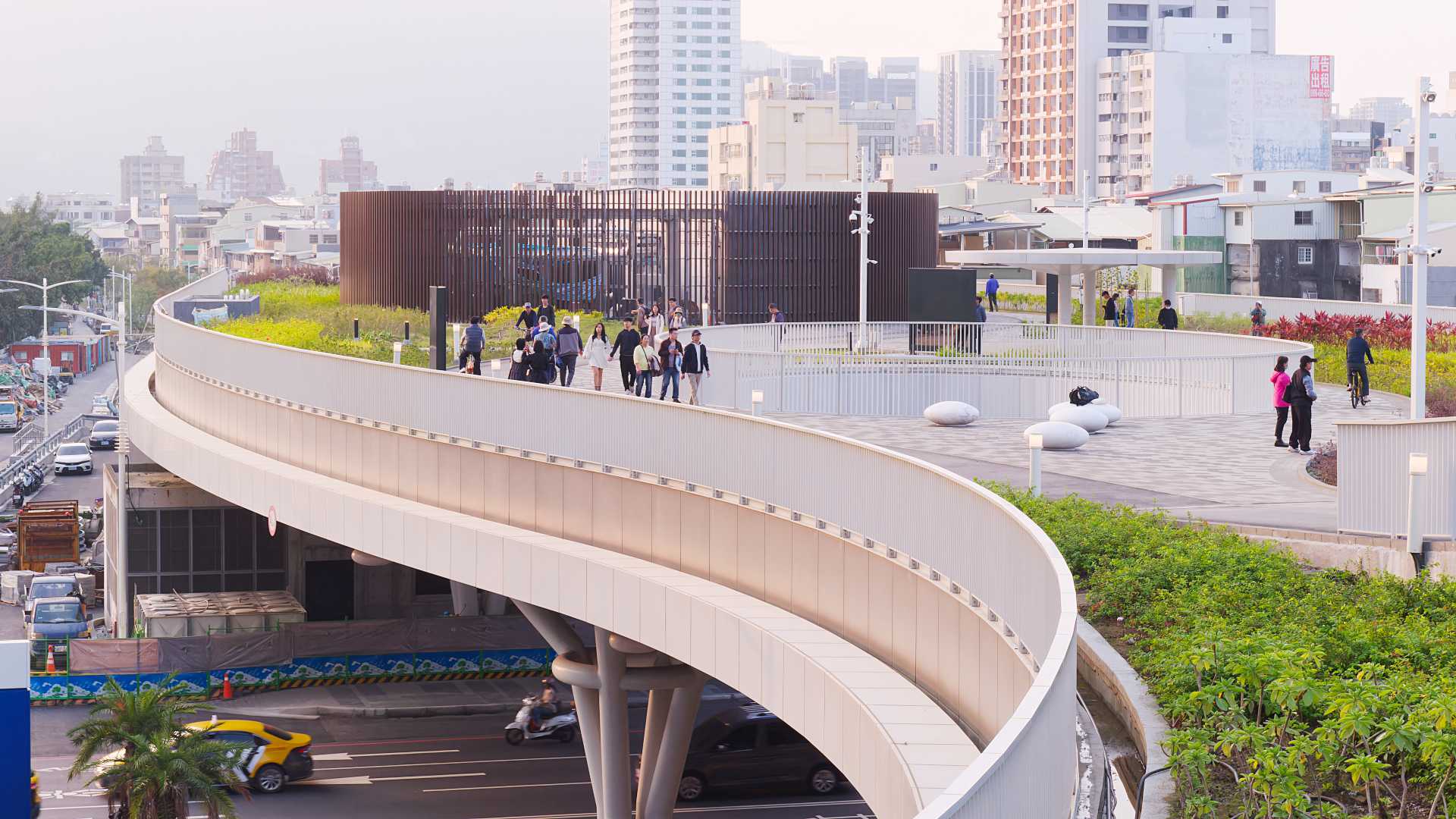 Groups of people strolling on the rooftop garden at Kaohsiung Station.