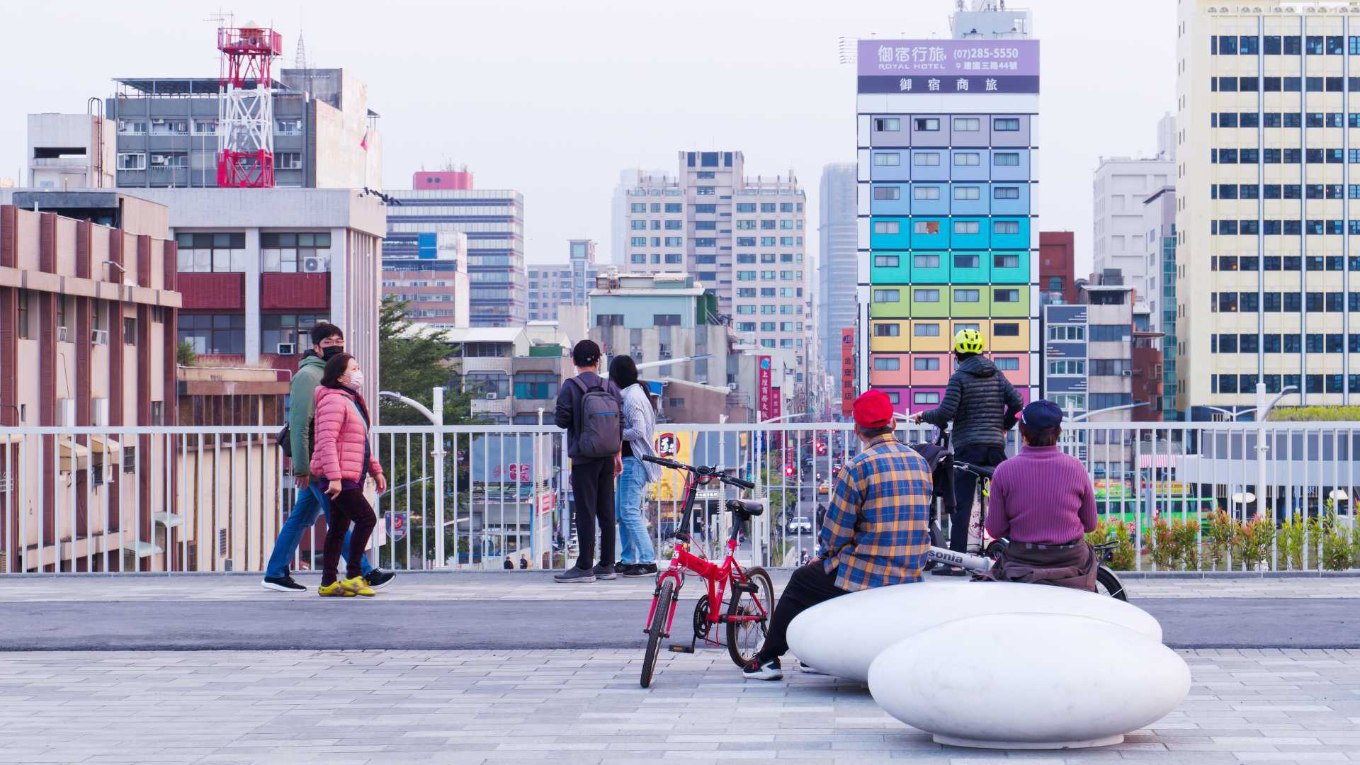 People looking out at the city scape from the roof garden of Kaohsiung Station.