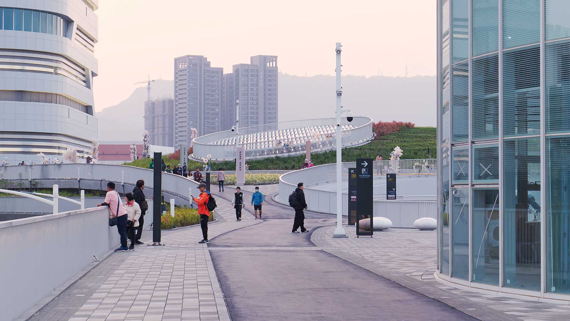 People walking on the rooftop walkway at Kaohsiung Station.