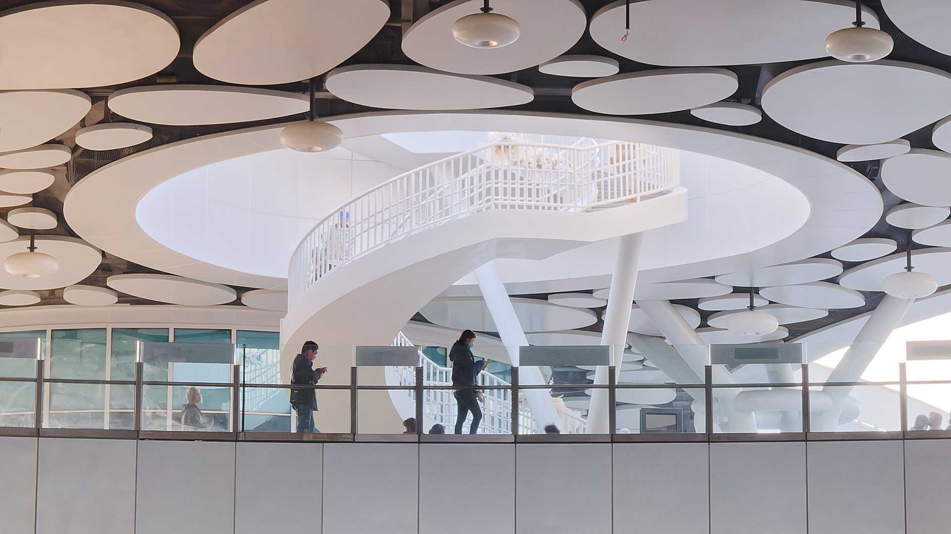 A white spiral staircase, descending from the rooftop.