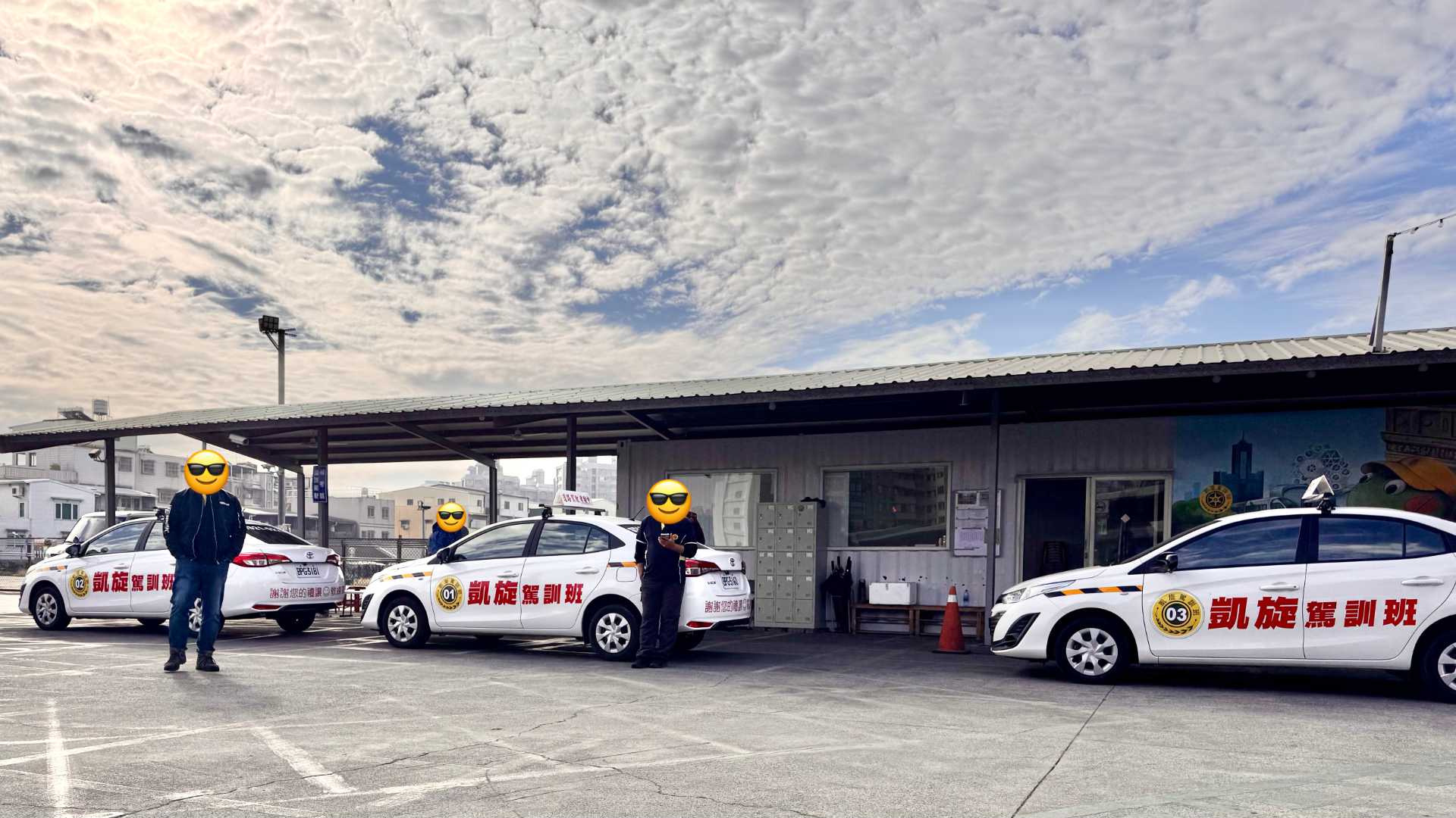 Three clean, modern cars parked at a driving school in Kaohsiung, Taiwan. The cars have Chinese-language signage on them, and are numbered 1 to 3.