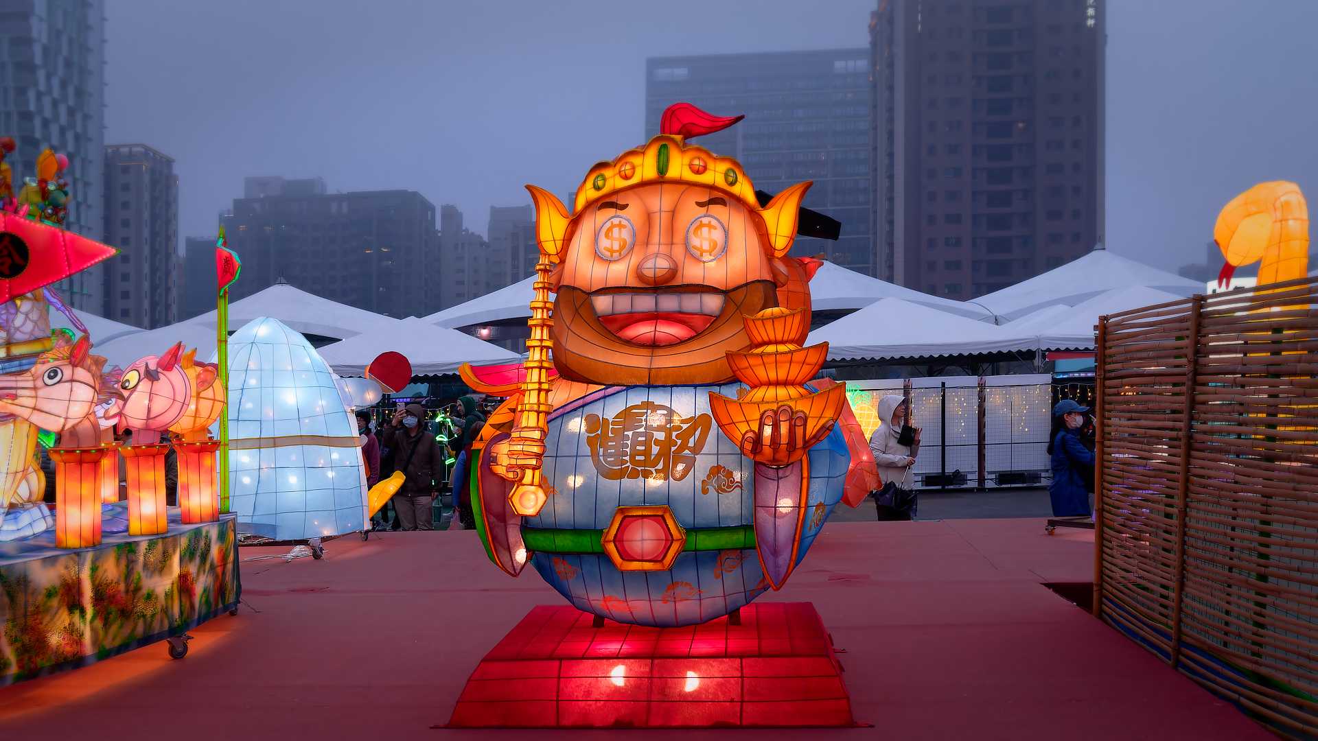 Lantern in the shape of a folklore character holding gold ingots.