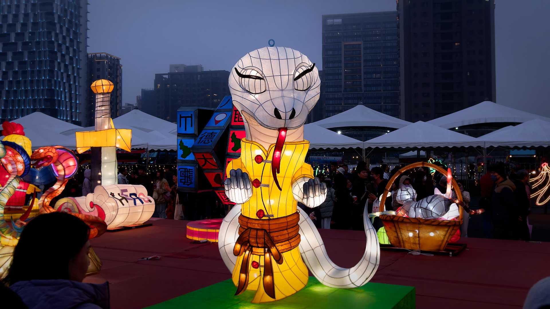 Lantern in the shape of a white snake with two arms, doing martial arts.