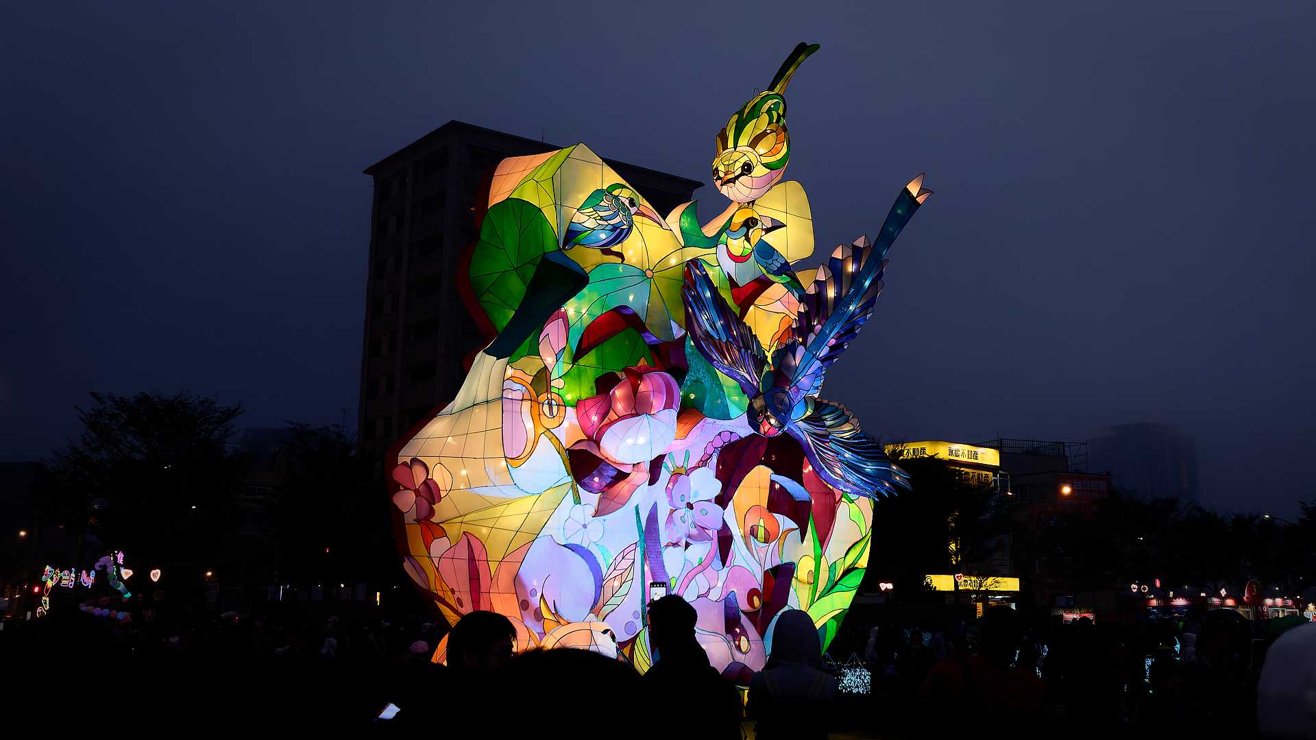 Lantern in the shape of numerous birds and other patterns, creating a two-to-three-story tall structure.