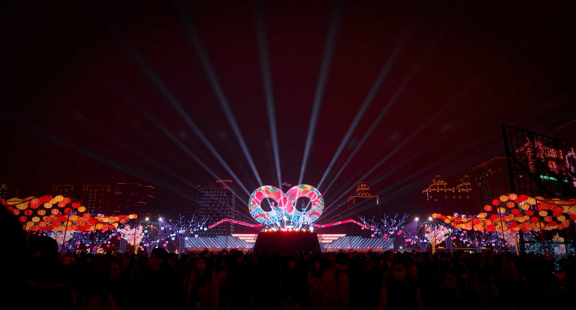 A wide-angle shot of crowds of thousands of people surrounding the main lantern at the 2025 Taiwan Lantern Festival in Taoyuan.