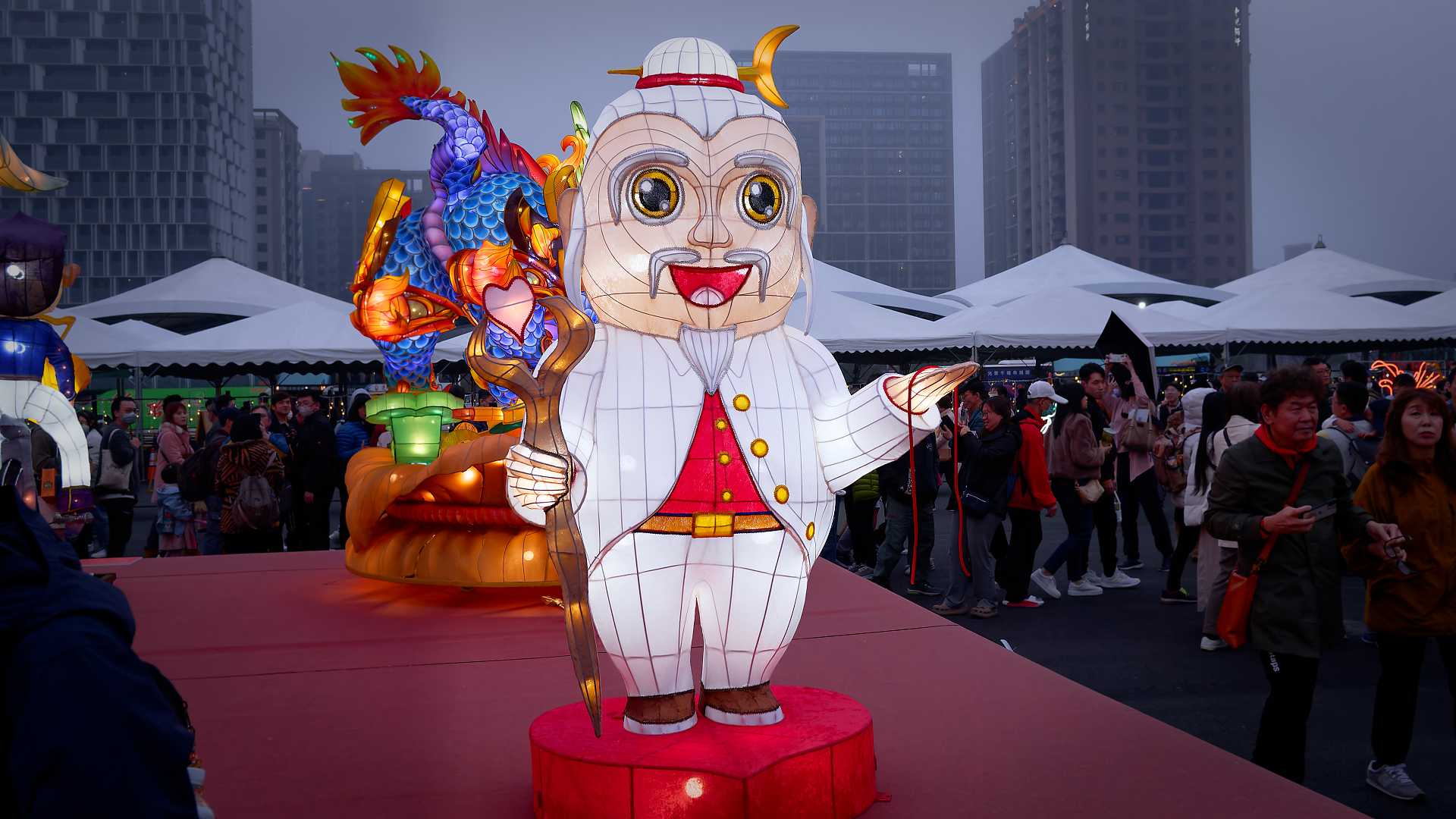 Lantern in the shape of a 19th-Century gentleman holding a wooden staff and some red string.