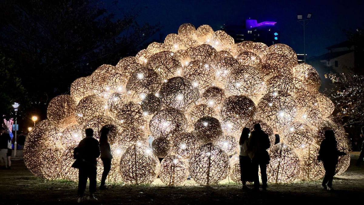 People silhouetted against an illuminated sculpture at Tainan 400 lantern festival in Taiwan.