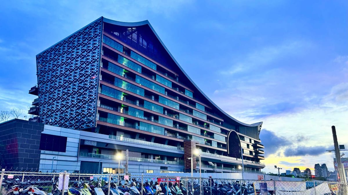 The new Fongshan Station Building at sunset with scooters parked in the foreground.